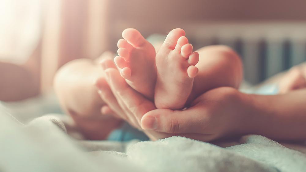 Person holding a baby's feet.