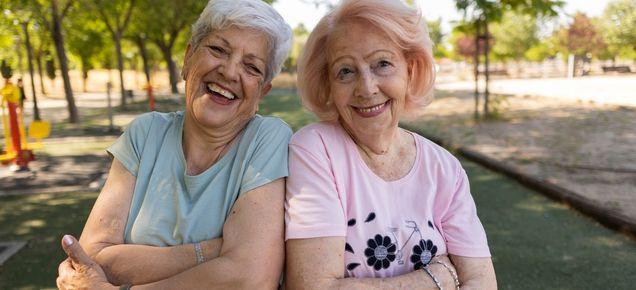 two older ladies sitting together and smiling