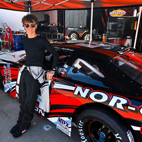 Colton Nelson stands with the stock car he races on the All-American Speedway.