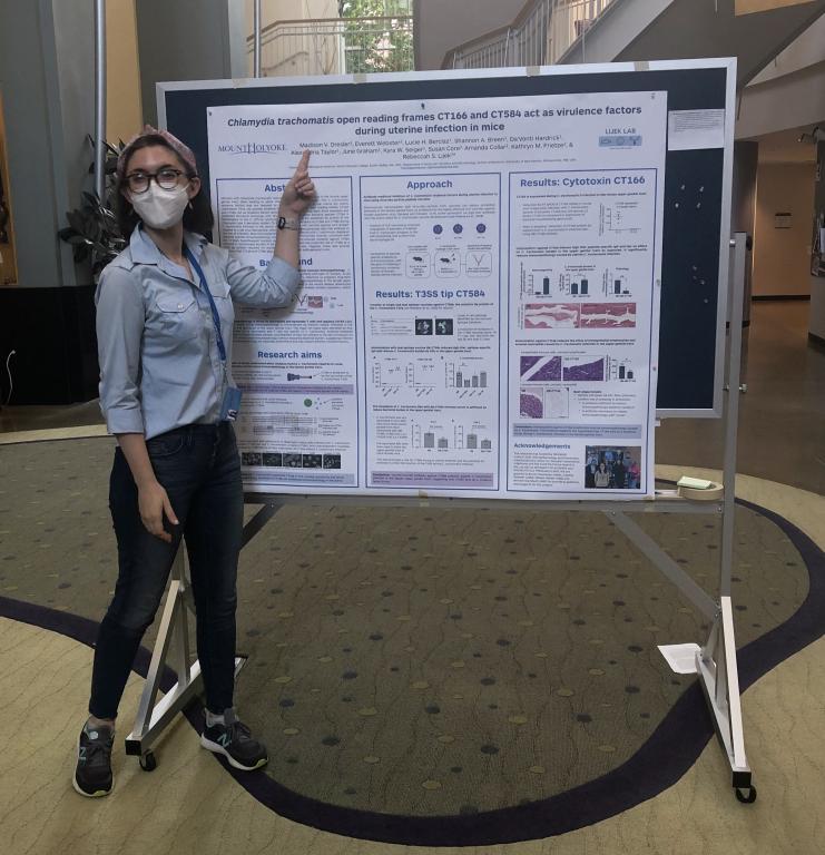 Madison Dresler stands next to a poster showing her research