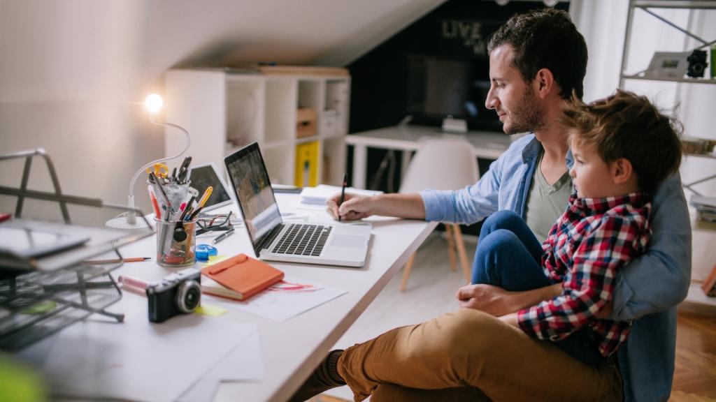 Man with child sitting on his lap on the computer.