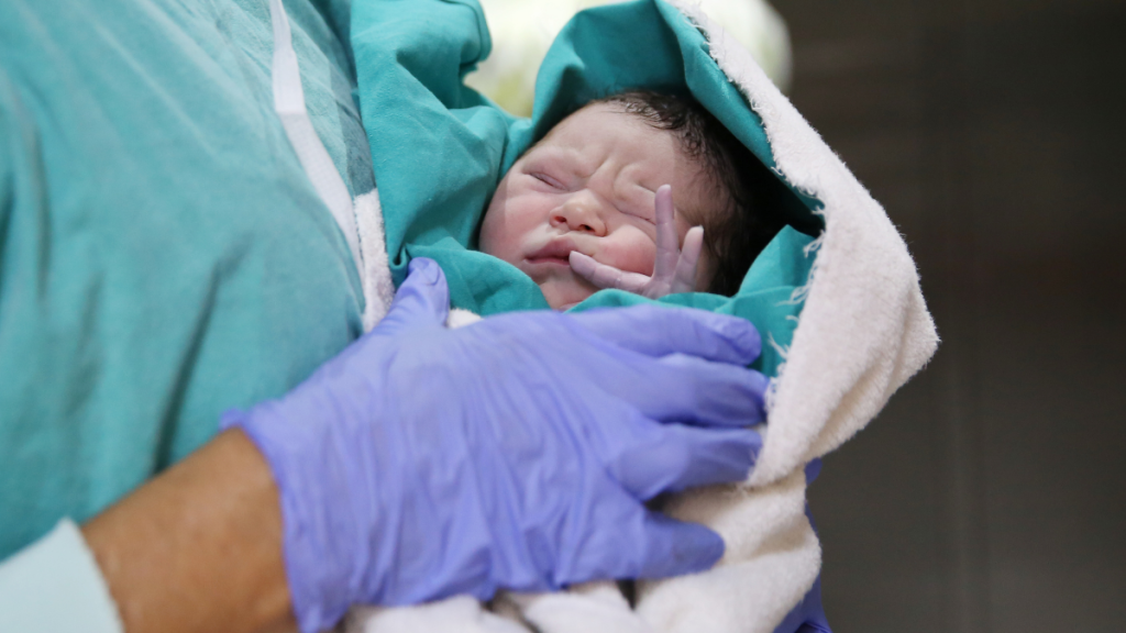baby in arms of nurse