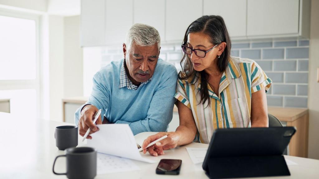Older adult couple looking through paperwork.