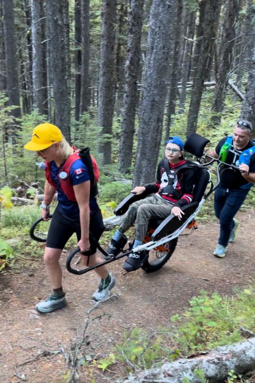 Parents pushing Alex Oliver in adaptive wheelchair