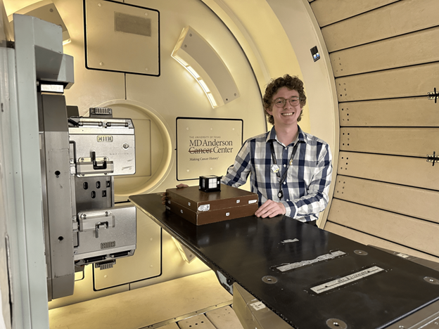 Hayden Scott as a adult standing in a radiation machine.