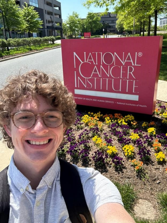Hayden Scott as an adult in front of MD Anderson National Cancer Institute sign