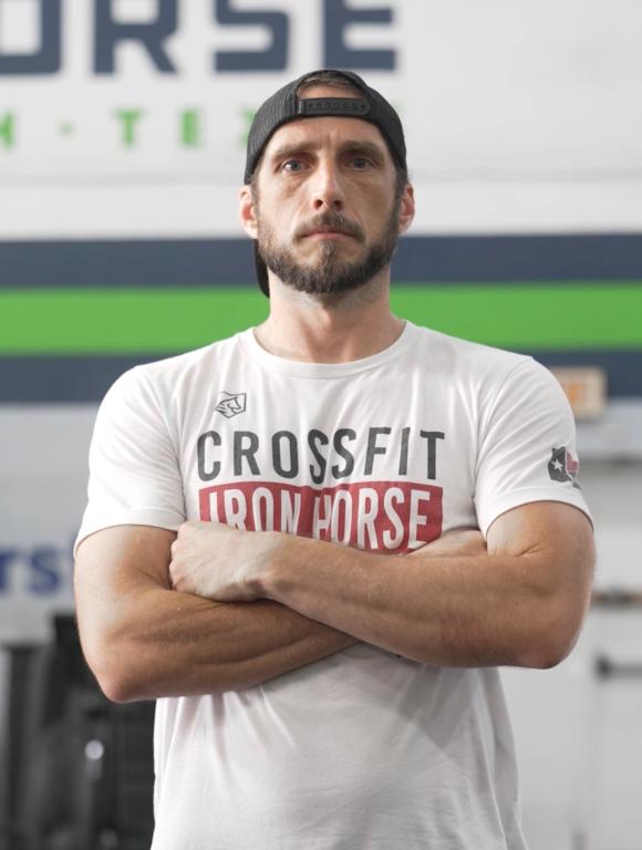 Chris Simpson poses with his arms crossed at the gym