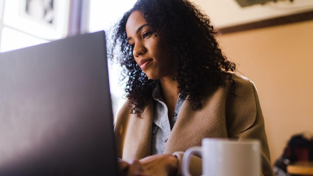 woman talking at computer with coffee