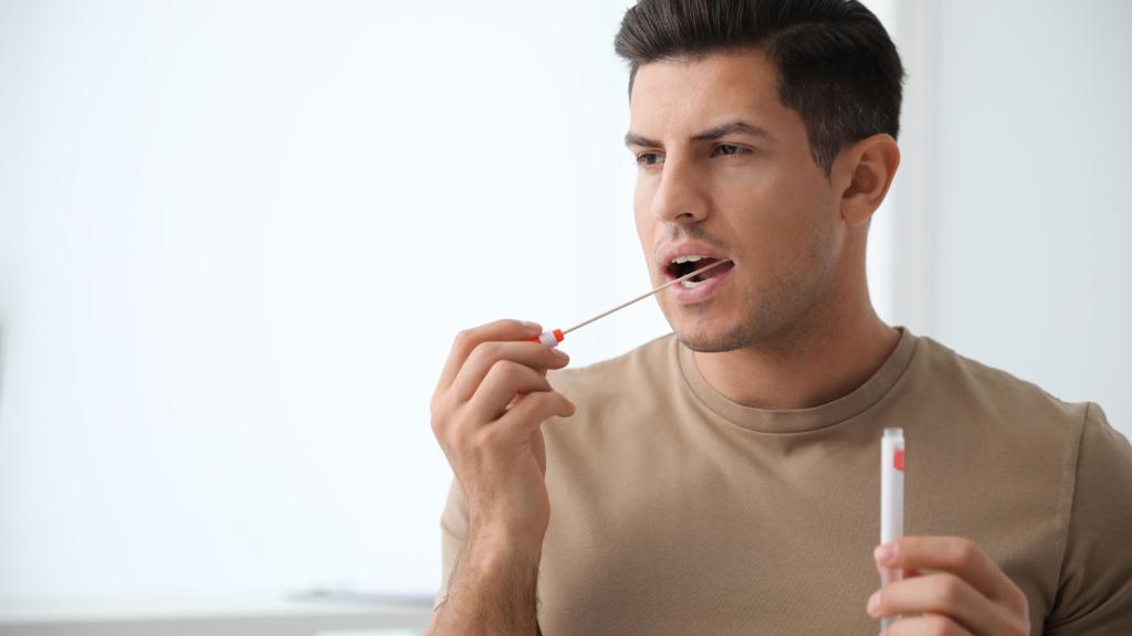 Man swabs his cheek for a genetic test.