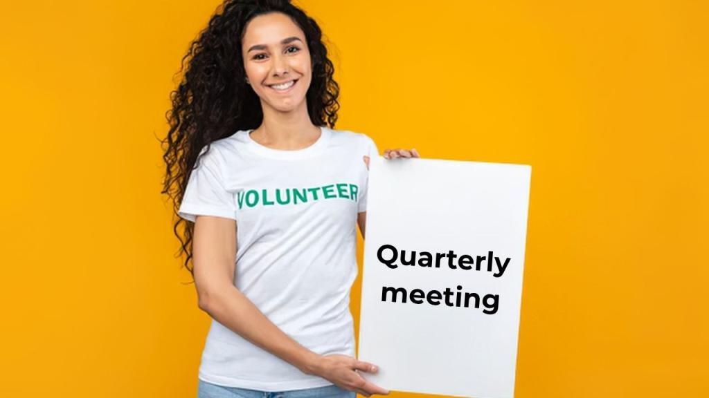 girl with t-shirt and sign reading quarterly meeting