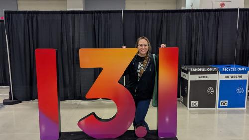 Chrissy Prickard posing behind a large number sign