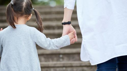 Child and adult holding hands