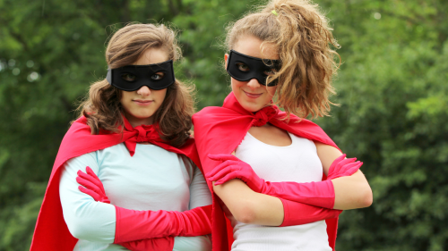 Two young women dressed as superheroes.
