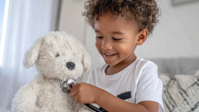 Child uses stethoscope on stuffed dog.
