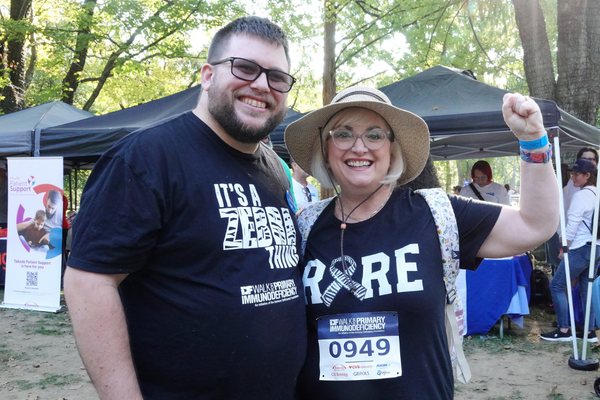 Man and woman posing together. Woman is flexing in the image. 