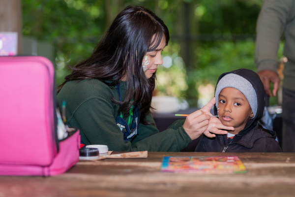 Small child receiving a face painting. 