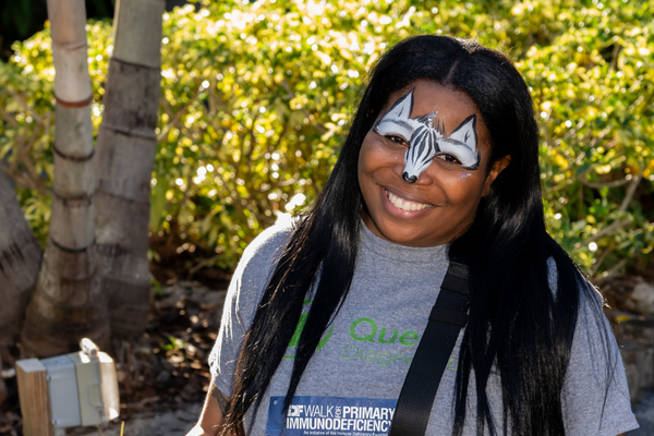 Woman smiling with a zebra face painting.
